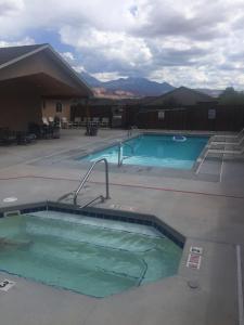 Una gran piscina en un complejo con montañas al fondo. en Oleander Place, en Moab