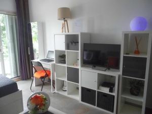 ein Wohnzimmer mit einem weißen Entertainment-Center mit einem TV in der Unterkunft Studio Chic Saint-Martin in Marigot