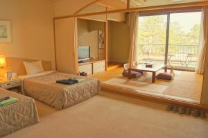 a hotel room with two beds and a large window at Amanohashidateso in Miyazu