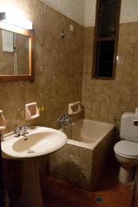 a bathroom with a sink and a tub and a toilet at Delfini Apartments in Kissamos