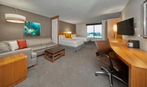 um quarto de hotel com um sofá e uma cama em Hyatt Place Eugene/Oakway Center em Eugene