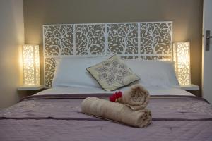 un letto con un asciugamano e un peluche sopra di Villa Améthyste avec grande piscine privée, jardin clos, parking privé a Le Robert Altre 19 foto
