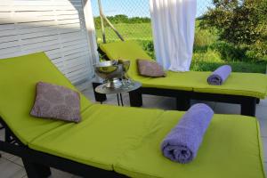 zwei grüne Stühle auf einer Veranda mit Handtüchern drauf in der Unterkunft Villa Améthyste avec grande piscine privée, jardin clos, parking privé in Le Robert