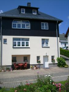 una casa blanca con techo negro en Am Dürrenbachtal en Klingenthal