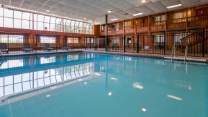 een groot zwembad met blauw water in een gebouw bij Sturgis Lodge and Suites in Sturgis