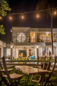 a house at night with a table and chairs at Aaki Hotel in Las Peñitas