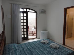 a bedroom with a bed with two pillows on it at Hotel Regência in São Lourenço