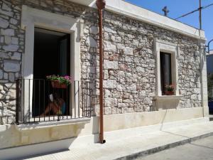 un bâtiment avec une fenêtre et un chien sur un balcon dans l'établissement La casa di Bice, à Cassibile