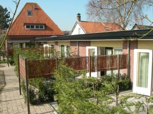 a house with a fence in front of a garden at Pension Kamperland in Kamperland