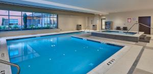 a large swimming pool with blue water in a building at Hyatt Place Eugene/Oakway Center in Eugene