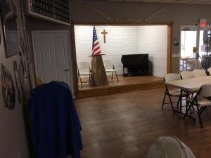 a room with a cross and a table and chairs at Woody's RV Resort LLC in Sebring