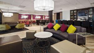 a hotel lobby with a couch and a bar at Best Western Plus Kingston Hotel and Conference Center in Kingston