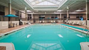 a large swimming pool with blue water in a building at Best Western Plus Kingston Hotel and Conference Center in Kingston