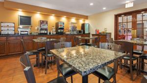 a restaurant with tables and chairs and a television at Best Western Plus Fort Wayne Inn & Suites North in Fort Wayne