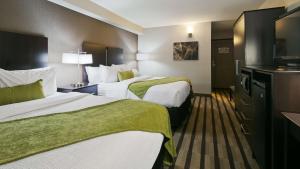 a hotel room with two beds and a television at Best Western Harvest Inn & Suites in Grand Forks +20 photos