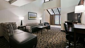 Best Western Ramkota Hotel Aberdeen في أبردين: غرفة في الفندق مع أريكة وتلفزيون
