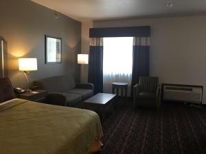 a hotel room with a bed and a couch at SureStay Plus by Best Western Edmond in Edmond