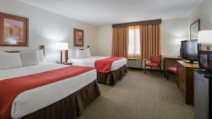 a hotel room with two beds and a flat screen tv at Best Western La Grande Hacienda in Cherokee +9 photos
