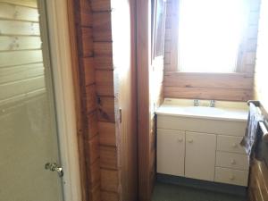 a bathroom with a sink and a window at Kairaki Beach Motor Camp in Wetheral +5 photos