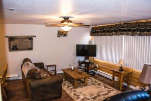 a living room with a couch and a tv at Aspen Meadow Cabin in Duck Creek Village