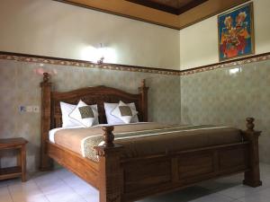 um quarto com uma cama de madeira num quarto em Eka's Homestay em Ubud
