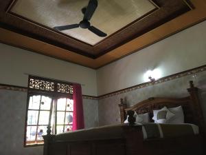 una camera con ventilatore a soffitto e letto di Eka's Homestay ad Ubud