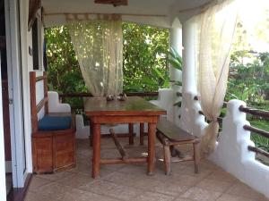 a porch with a wooden table and a chair at Villa La Caleta in Las Galeras