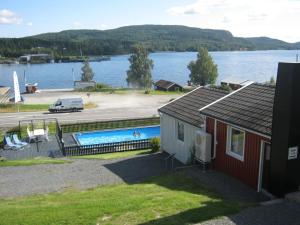 a house with a swimming pool next to a lake at Dockstabaren Hotel in Docksta