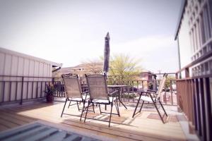 three chairs and a table on a deck at Okaeri in Anping