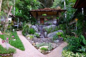 a garden in front of a house with flowers and rocks at Kiriraya Resort in Ao Nang Beach