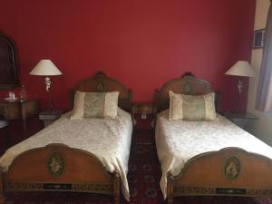 2 Betten in einem Zimmer mit roten Wänden in der Unterkunft Villas Sol y Luna Coyoacan in Mexiko-Stadt