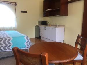 eine Küche und ein Esszimmer mit einem Tisch und einem Bett in der Unterkunft Villas Sol y Luna Coyoacan in Mexiko-Stadt