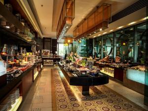 een restaurant met een buffet met mensen die eten bereiden bij Equatorial Ho Chi Minh City in Ho Chi Minh-stad