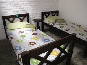 two beds in a room with flowers on them at Pousada Joãozinho Caminhador in Recife