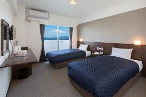 um quarto de hotel com duas camas e uma janela em Global Resort Miyajima View em Hatsukaichi