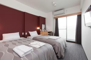 Voodi või voodid majutusasutuse Global Resort Miyajima View toas