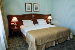 a bedroom with a large bed with two lamps at Hotel Zentralnaya in Troitsk