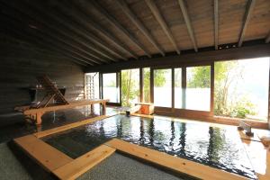 a swimming pool in a room with windows and water at Ryokan Kono-Yu in Minamioguni