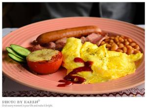 un piatto di prodotti per la colazione con uova in fagioli e hot dog di Wishingwell B&B a Donghe Altre 29 foto