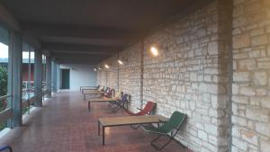 a row of tables and chairs against a brick wall at Theoxenia Hotel in Andritsaina