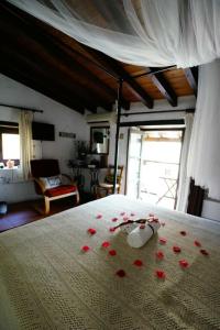 1 dormitorio con 1 cama con pétalos de rosa rojo en Irene's House, en Kakopetria