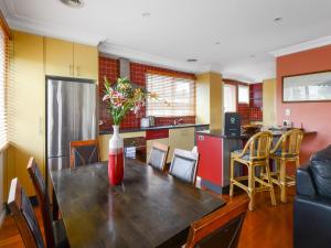 a kitchen with a table with a vase of flowers on it at BOUTIQUE STAYS - Sandy Haven C in Sandringham