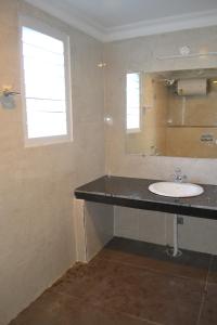 um banheiro com uma pia e um espelho em Swiss Cottage em Kodaikānāl