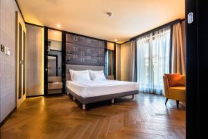 a bedroom with a bed and a chair in a room at Eurostars Sofia City in Sofia