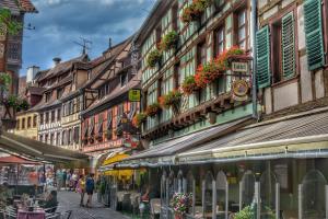 eine Straße mit Gebäuden und Menschen, die eine Straße entlanggehen in der Unterkunft Hôtel Sainte Odile in Obernai