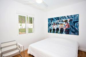 a white bedroom with a bed and two windows at Luxury Apartments with private swimming pool in Marbella +37 photos