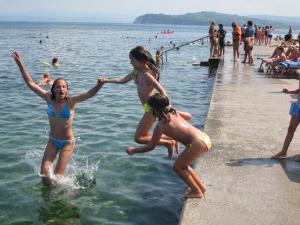 two girls playing in the water at the beach at Apartment Verdi in Piran