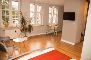 uma sala de estar com piso de madeira e janelas em Apartament - Old Town Studio em Gdansk
