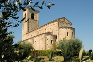 an old stone building with a clock tower on it at La Stanza Di Alice in Ponzano di Fermo