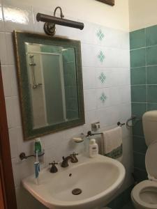un bagno con lavandino, specchio e WC di villa vista mare spiaggia privata a Scopello Altre 49 foto